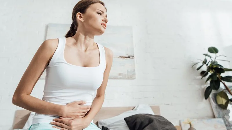 giardiyaz hastalığı yüzünden ağrı yaşayan kadın