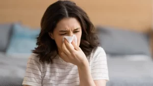 burun tıkanıklığı yaşayan burnunu silen kadın