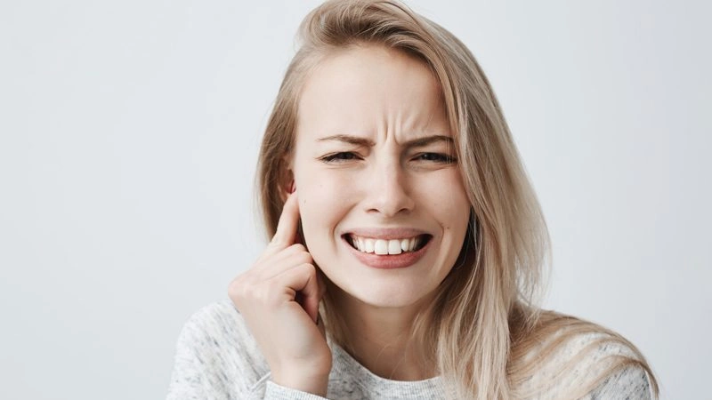 kulak ağrısı olan sarışın kadın