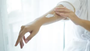 Kuru cilt için nemlendirici kullanan kadın