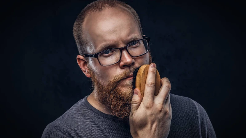 sakal ekiminde greft sonrası gür sakallarını tarayan gözlüklü adam