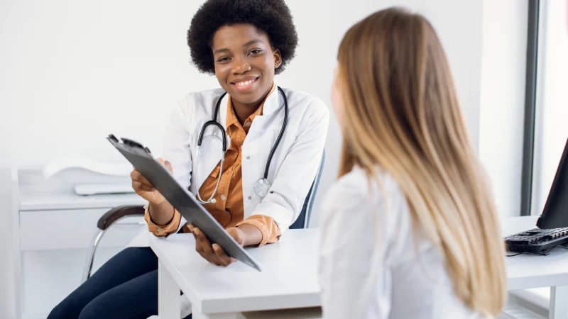 geniz eti ameliyatı riskleri hakkında bilgi veren doktor ve kadın hasta