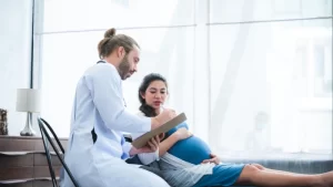 Sezaryen normal doğum arasındaki farkları konuşan doktor ve kadın