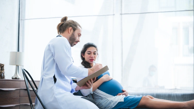 Sezaryen normal doğum arasındaki farkları konuşan doktor ve kadın