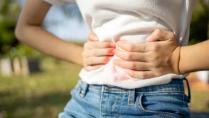 Mide Şişkinliği Hangi Hastalıkların Habercisidir? - midesini tutan bir kadın