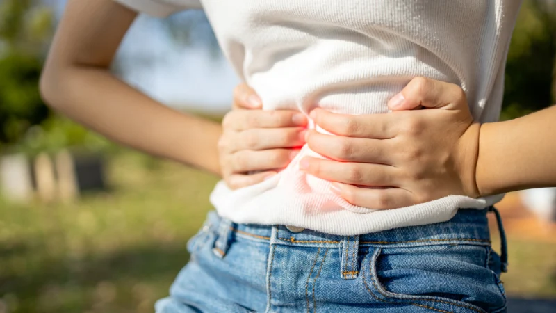 Mide Şişkinliği Hangi Hastalıkların Habercisidir? - midesini tutan bir kadın