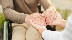 Hemipleji Etkili Tedavisi- doktor ve hemipleji hastası el ele tutuşuyor.