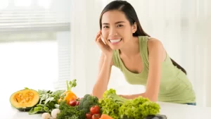 Ödem Söktürücü Besinler - sağlıklı besinlerin arkasında gülümseyen bir kadın