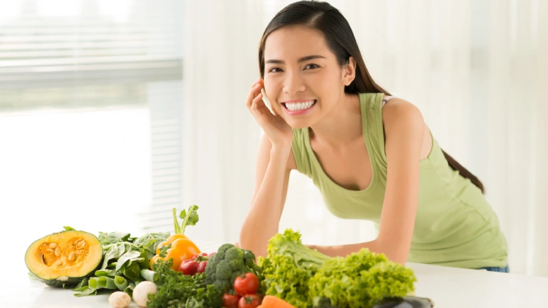 Ödem Söktürücü Besinler - sağlıklı besinlerin arkasında gülümseyen bir kadın