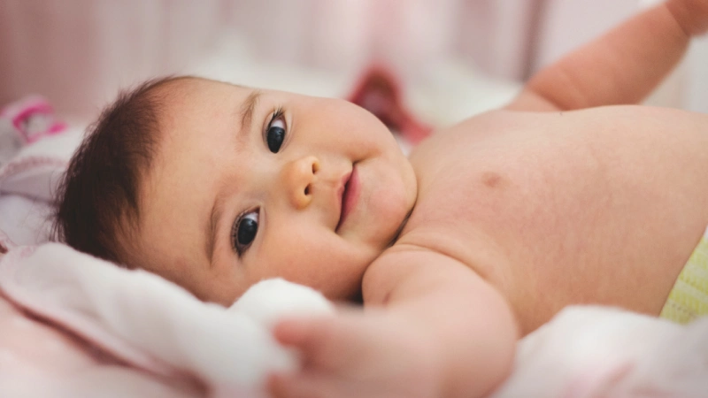 Tortikolis Hastaları İçin Fizik Tedavi Önemi- yatarak gülümseyen bebek